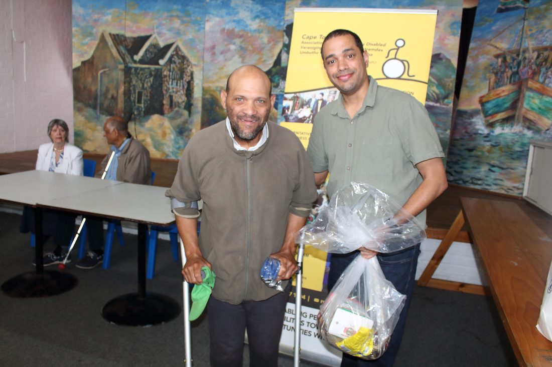 A member receiving support parcels from CTAPD staff at a community handover